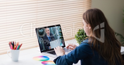 Businesswoman video conferencing with colleague on laptop