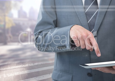 Man mid section with tablet against blurry street with flares