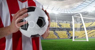 Midsection of player holding soccer ball