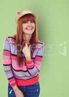 Portrait of happy female hipster wearing sweater against green background