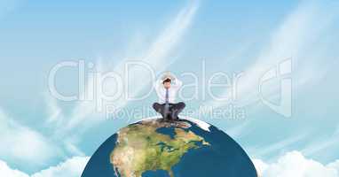 Businessman meditating on earth against sky