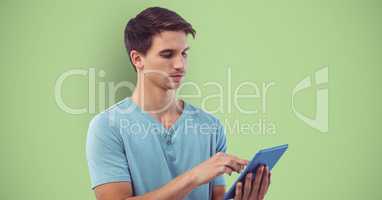 Young man using tablet computer over green background