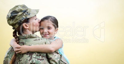 Soldier mother and daughter against yellow background