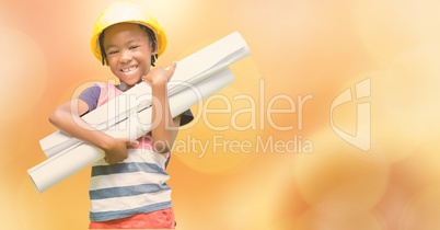 Little girl holding blueprints over blur background