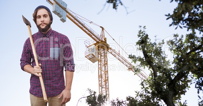 Hipster holding ax against crane