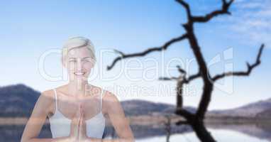 Double exposure of woman with hands clasped performing yoga