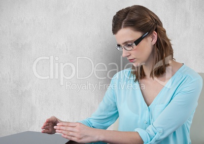 Businesswoman looking at hands against gray background