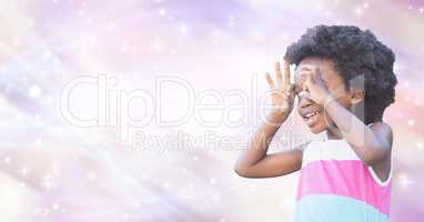 Little girl looking through finger binoculars over blur background