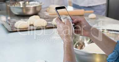 Hands photographing dough on smart phone