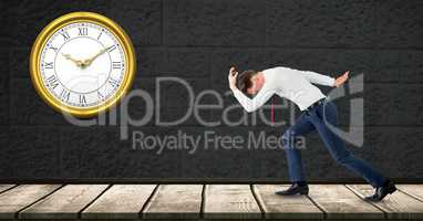 Side view of businessman running late with clock on wall