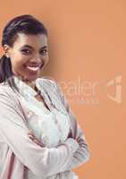 Portrait of smiling businesswoman standing arms crossed against orange background