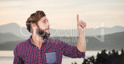 Hipsters pointing up against mountains
