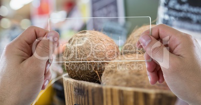 Hand photographing coconut through transparent device