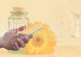 Hand holding glass screen next to sunflower and jar