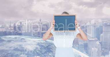 Businesswoman holding slate in front of face against globe and city