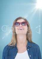 Close up of business woman with sunglasses and flare against blue background