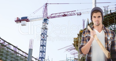 Confident hipster holding ax against crane