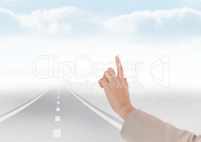 Hand touching sky with road