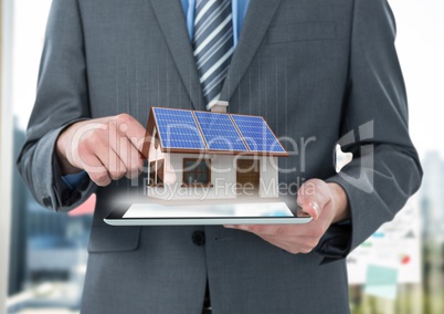 panels on the roof houses on tablet of the businessman