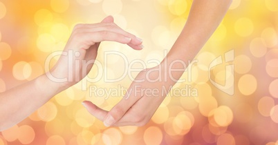 Close-up of hands against glowing bokeh