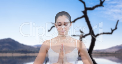 Double exposure of woman meditating with lake in background