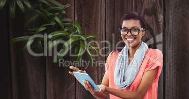 Smiling businesswoman using tablet PC against wall