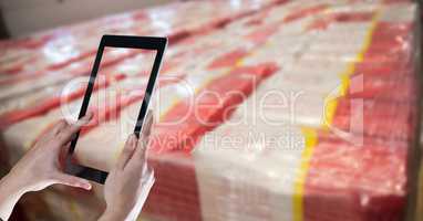 Hands taking picture with tablet PC in warehouse