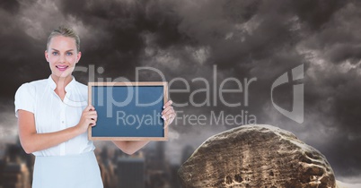 Businesswoman showing blank slate against cloudy sky