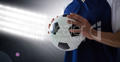 Midsection of player holding soccer ball