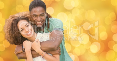 Happy man embracing woman over bokeh