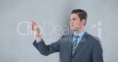 Businessman touching imaginary screen over gray background