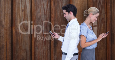 Business people using smart phones against wooden wall