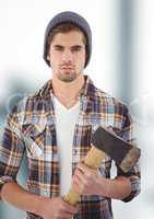 Confident hipster holding ax over blurred background