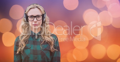 Female hipster using headphones against bokeh