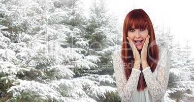 Surprised female hipster with snow covered trees in background