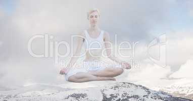 Double exposure of woman meditating on snow covered mountain