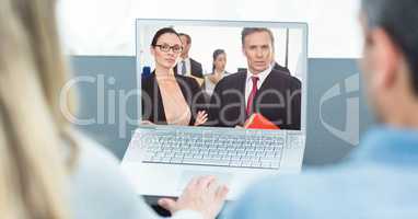 Rear view of business people video conferencing on laptop