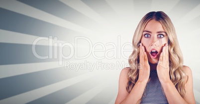 Shocked woman with hands on cheeks against bright background