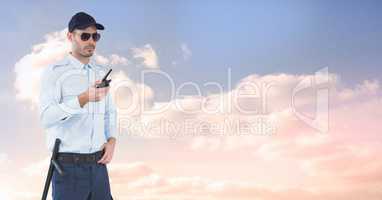 Security guard holding radio against sky