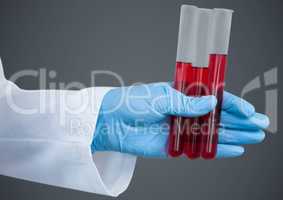 Gloved hand with red tubes against grey background