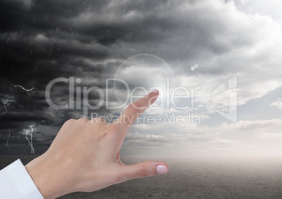 Hand pointing in air of dark stormy cloudy sky
