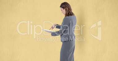 Businesswoman touching screen of tablet PC over beige background