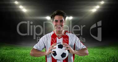 Happy player holding soccer ball