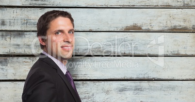 Portrait of confident businessman against wooden wall