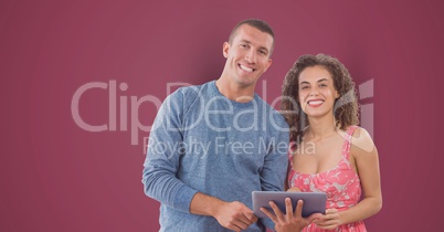 Portrait of smiling business people with digital tablet against pink background