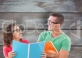 Happy business colleagues holding files against wooden wall