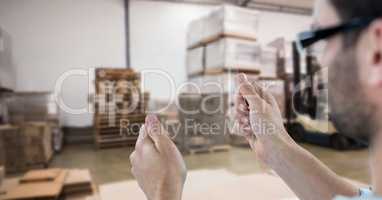 Man photographing goods through transparent device in warehouse