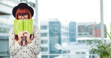Female hipster holding book in city