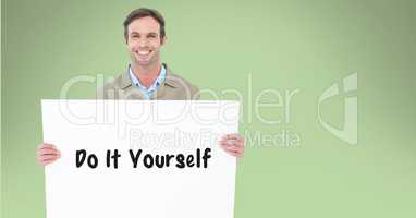 Portrait of man holding billboard with do it yourself text against green background