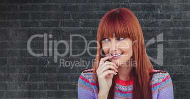 Smiling redhead woman against wall